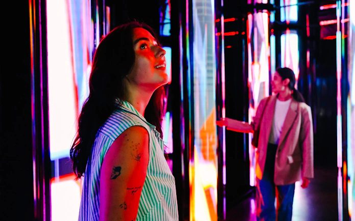 Visitors exploring vibrant light displays at Edge NYC Observation Deck.