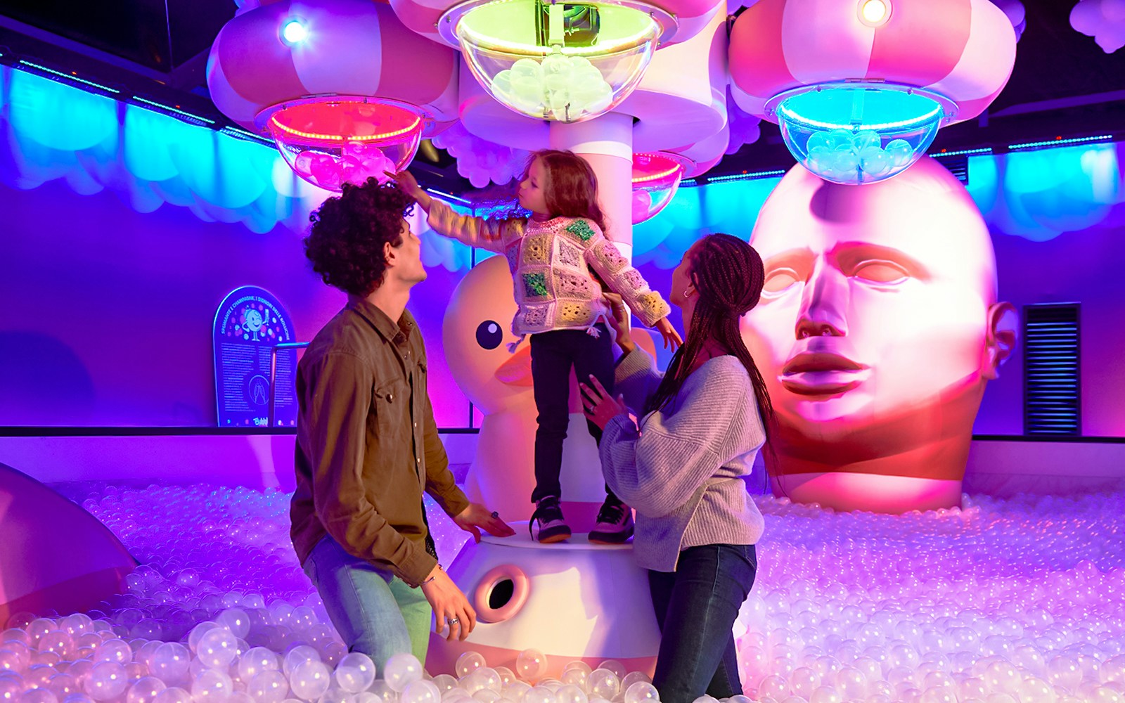 Family exploring Bubble Planet exhibit in Seattle with colorful lights and interactive displays.