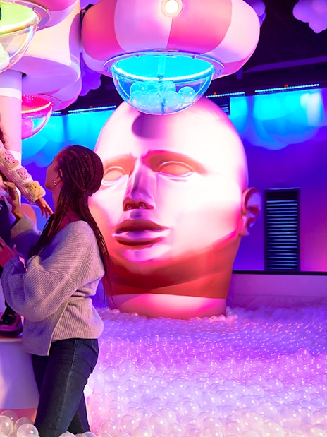 Family exploring Bubble Planet exhibit in Seattle with colorful lights and interactive displays.