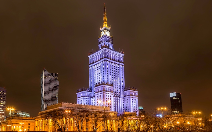 Palace of Culture and Science illuminated at night in Warsaw, Poland.