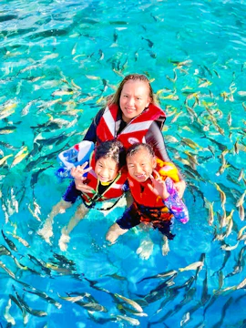 Snorkelers in Langkawi Marine Park surrounded by tropical fish.