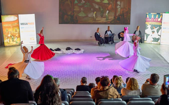 Whirling dervishes performing in Istanbul with musicians in the background.