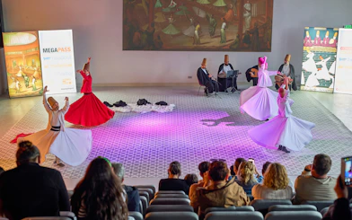 Whirling dervishes performing in Istanbul with musicians in the background.