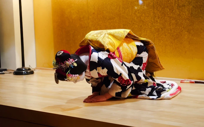 Geisha bowing during a traditional performance in Kyoto.