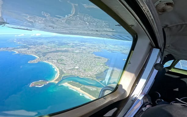 Aerial view of Shellharbour coastline from a plane during a tandem skydive near Sydney.