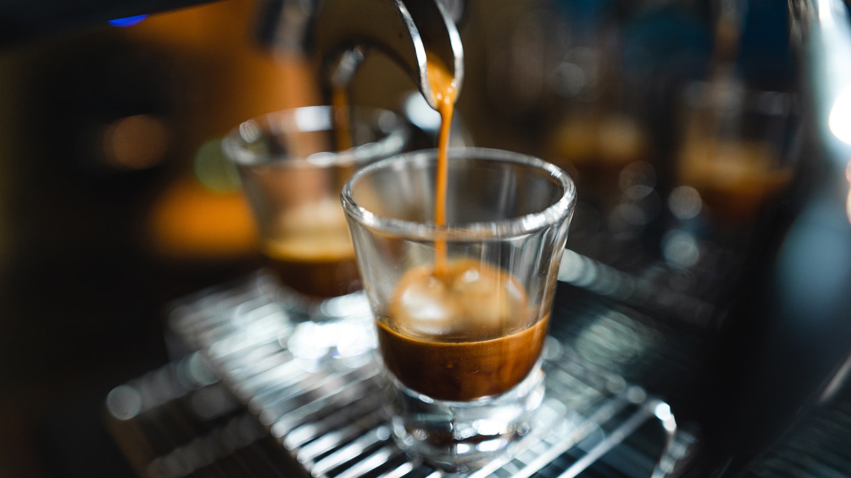 Espresso shot pouring into glass, highlighting single-origin coffee experience.