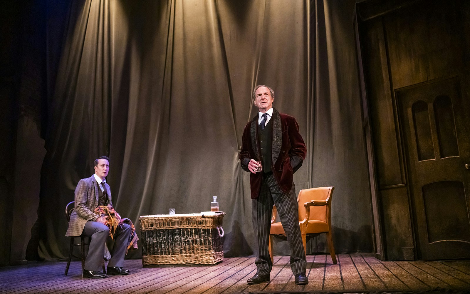 Actors performing a scene from "The Woman in Black" on stage.