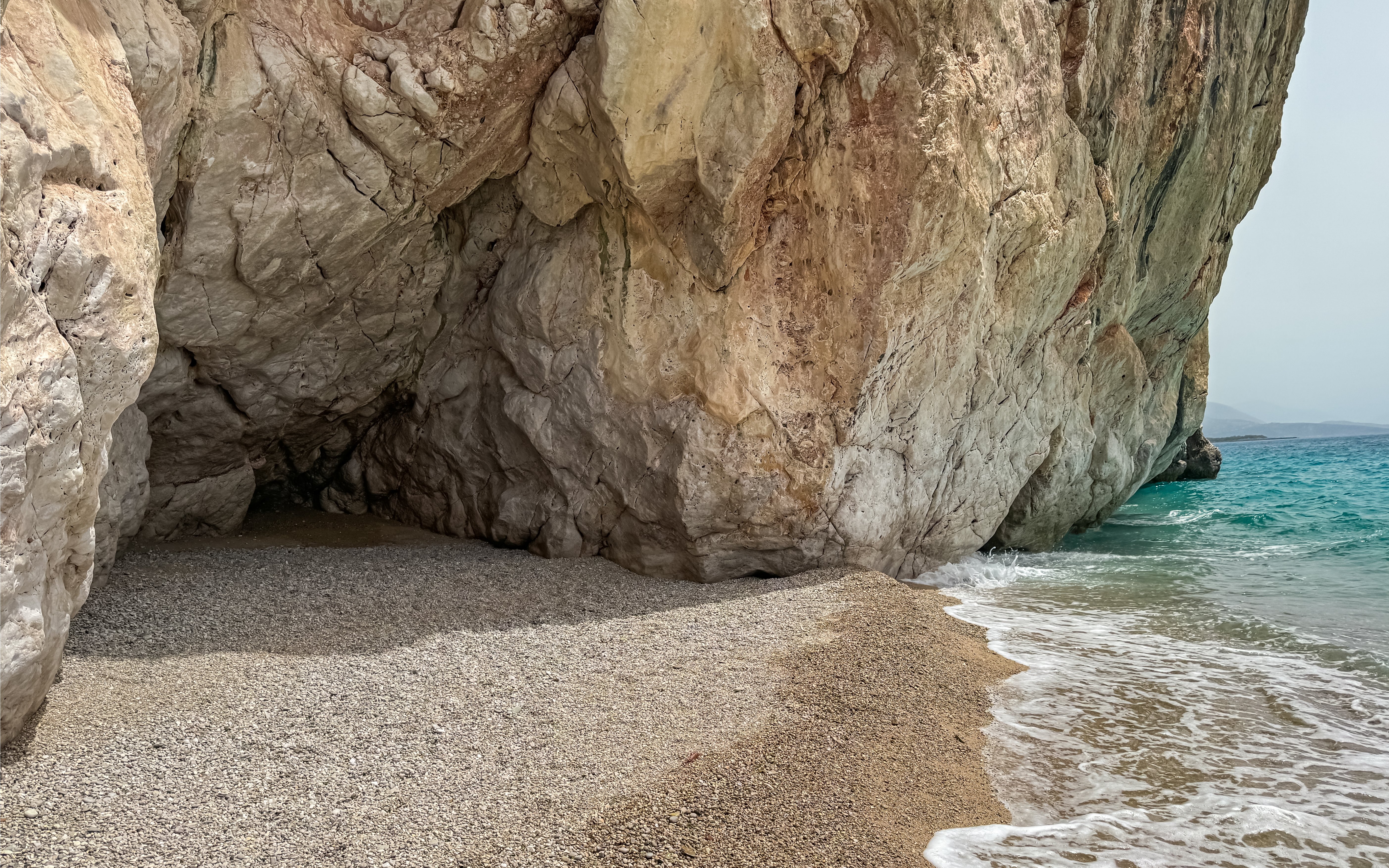 Secluded beach under large sea cave with natural archway in Himare, Albanian Riviera, Albania.