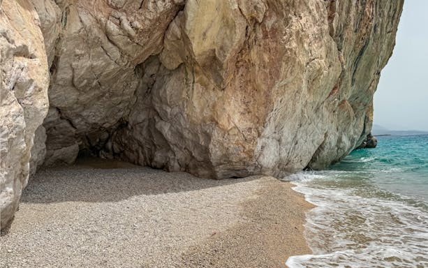 Secluded beach under large sea cave with natural archway in Himare, Albanian Riviera, Albania.