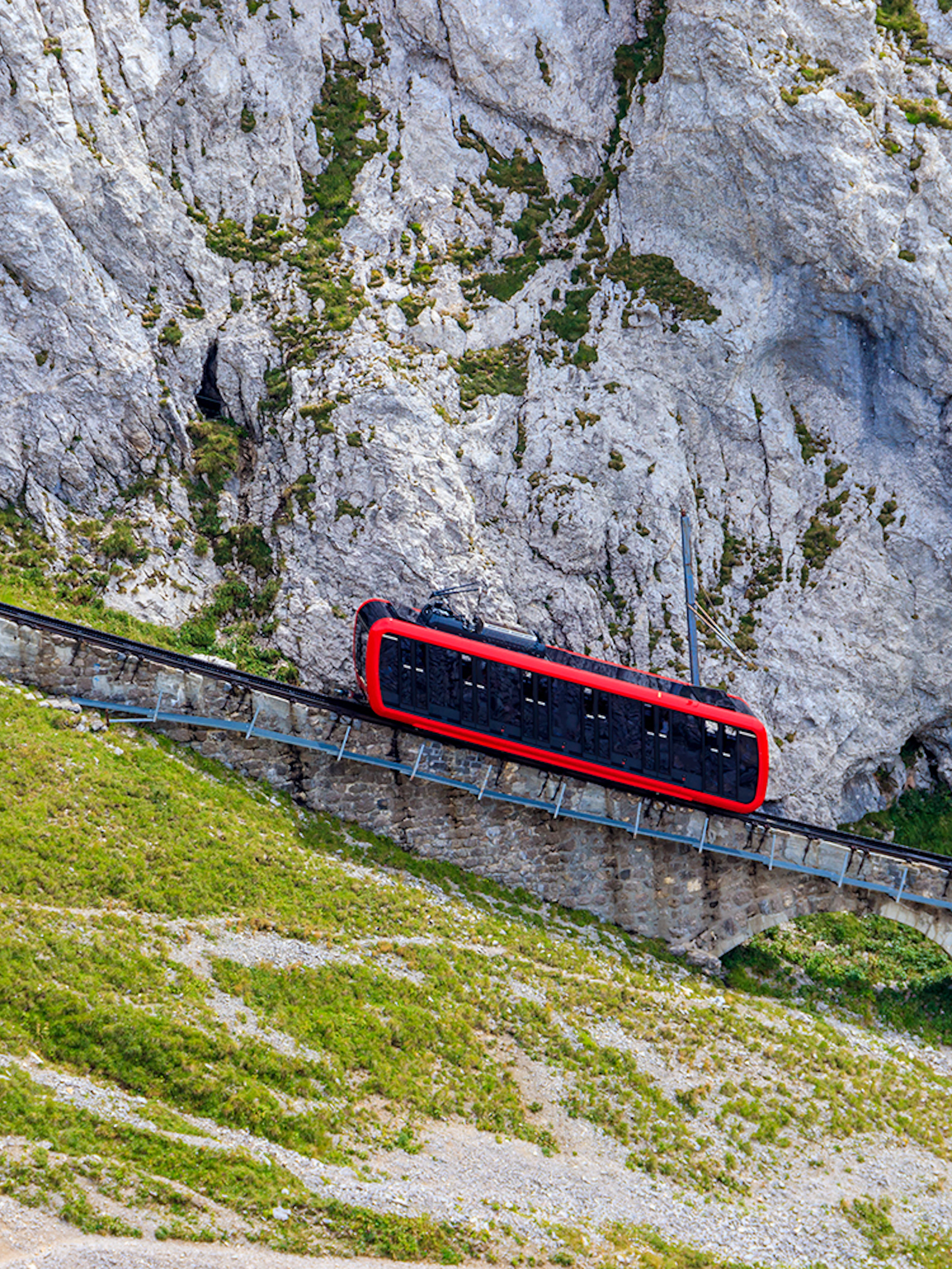 Red cogwheel train ascending Mount Pilatus near Lucerne, Switzerland.