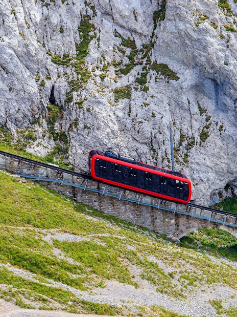 Red cogwheel train ascending Mount Pilatus near Lucerne, Switzerland.