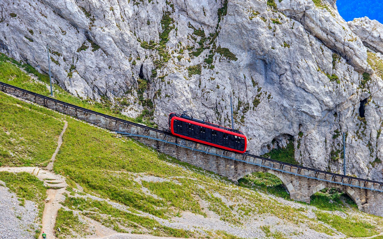 Red cogwheel train ascending Mount Pilatus near Lucerne, Switzerland.