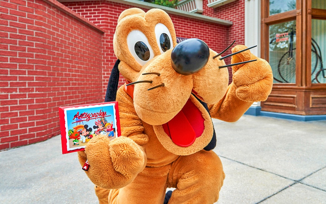 Character holding autograph book at Disneyland Paris.