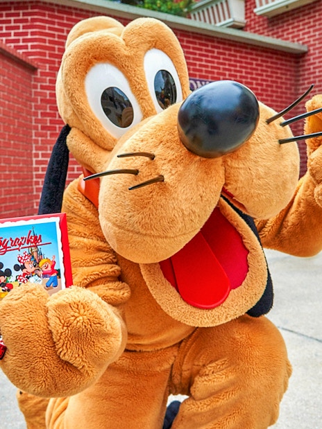 Character holding autograph book at Disneyland Paris.