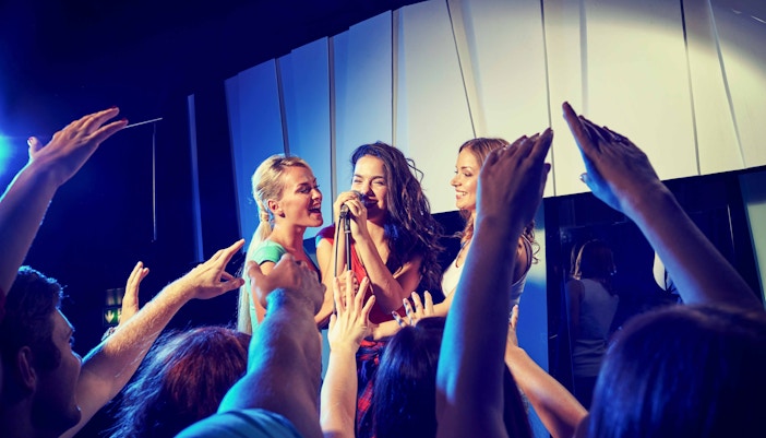Group singing at Moyagi Karaoke with audience cheering.