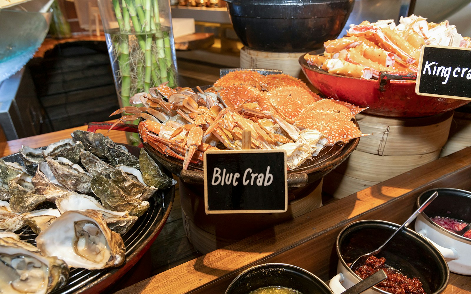 Blue crabs displayed at a seafood buffet with oysters and king crab.