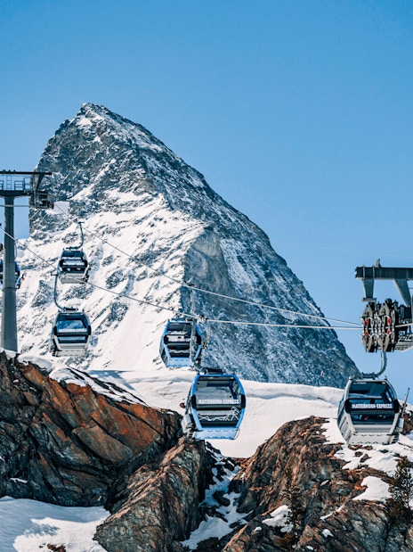 Cable cars traveling to Matterhorn Glacier Paradise with snowy mountain backdrop.