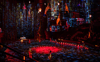 Acrobats performing in La Perle's City Rush show with vibrant cityscape backdrop.