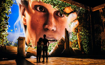 Couple viewing immersive Pompeia experience at IDEAL Barcelona with large digital display.
