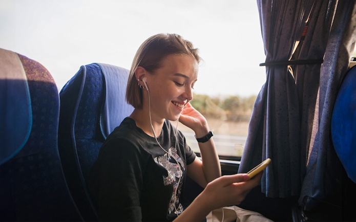 Person listening to music on a coach transfer.