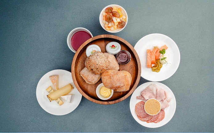 Breakfast spread with bread, cheese, meats, and fruit at Berliner Fernsehturm, Berlin.