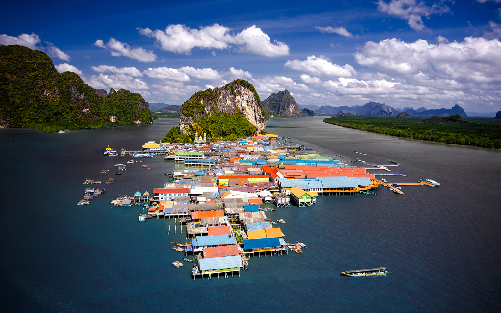 Aerial view of Koh Panyee, Thailand's floating village with colorful houses and limestone cliffs.