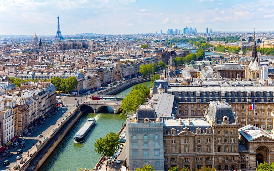Aerial view of Paris with the Eiffel Tower and Seine River near the Louvre Museum.