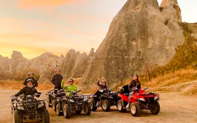 ATV riders exploring Cappadocia's unique rock formations at sunset.