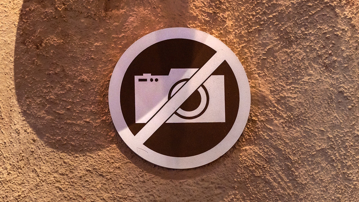 No photography sign on textured wall.
