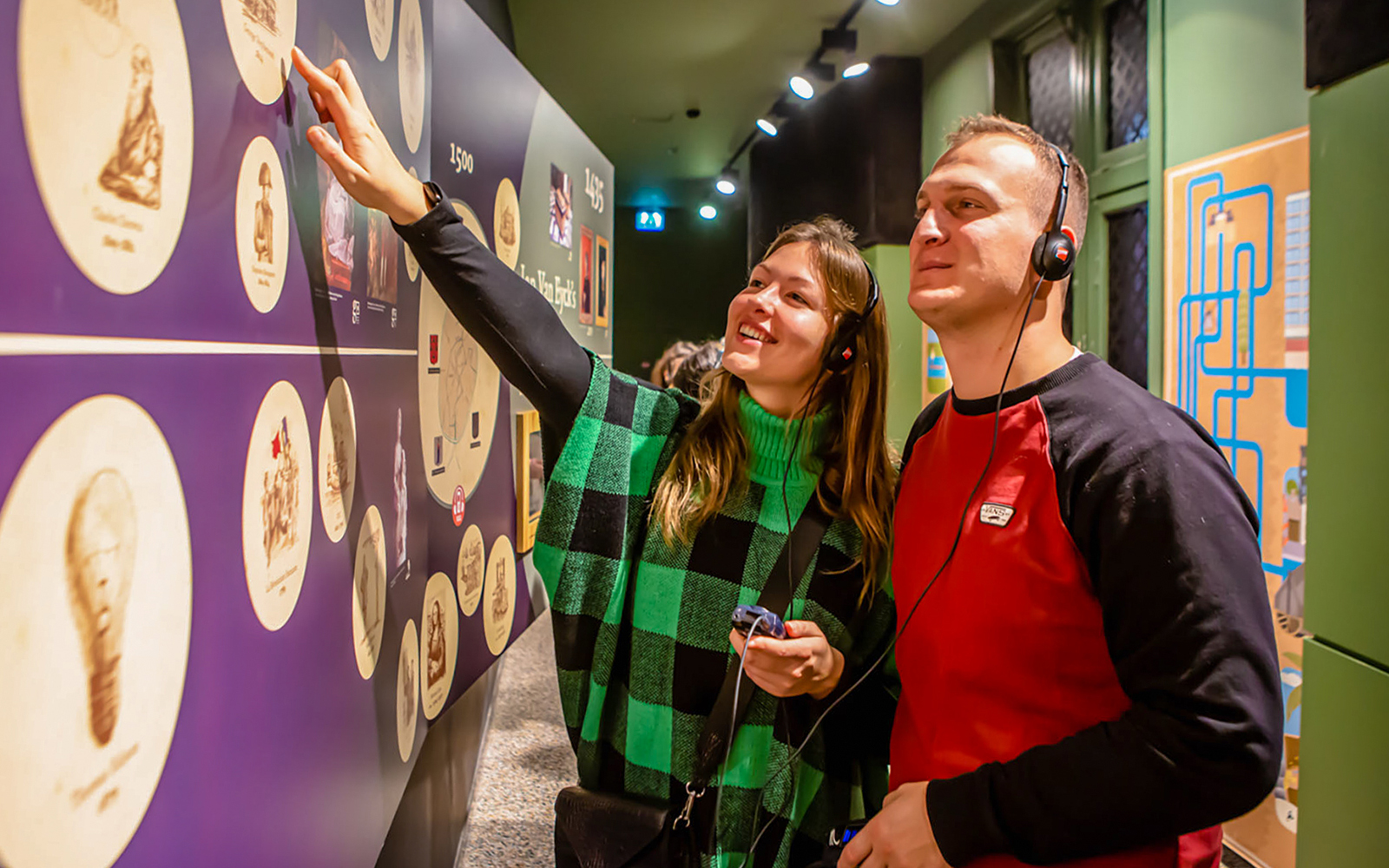Visitors exploring exhibits at Historium Bruges with audio guides.