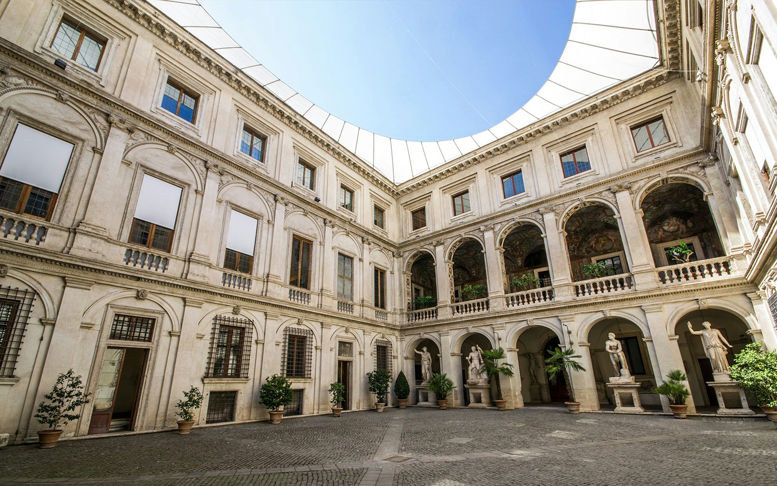 Courtyard of Museo Nazionale Romano with statues and arched balconies.