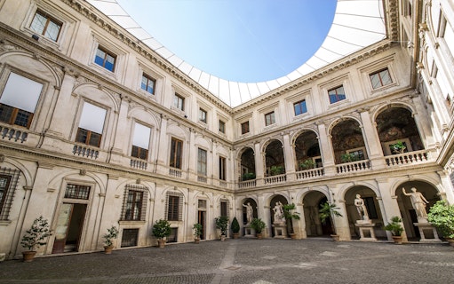 Courtyard of Museo Nazionale Romano with statues and arched balconies.