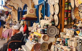 Colorful pottery and textiles displayed at a market stall in Essaouira, Safi Region Coastal Excursion.