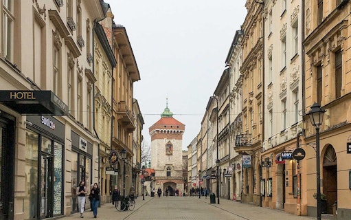 Krakow's Old Town street with St. Florian's Gate in the background.