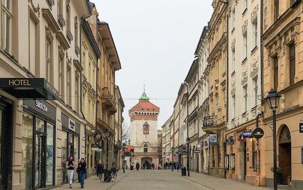 Krakow's Old Town street with St. Florian's Gate in the background.