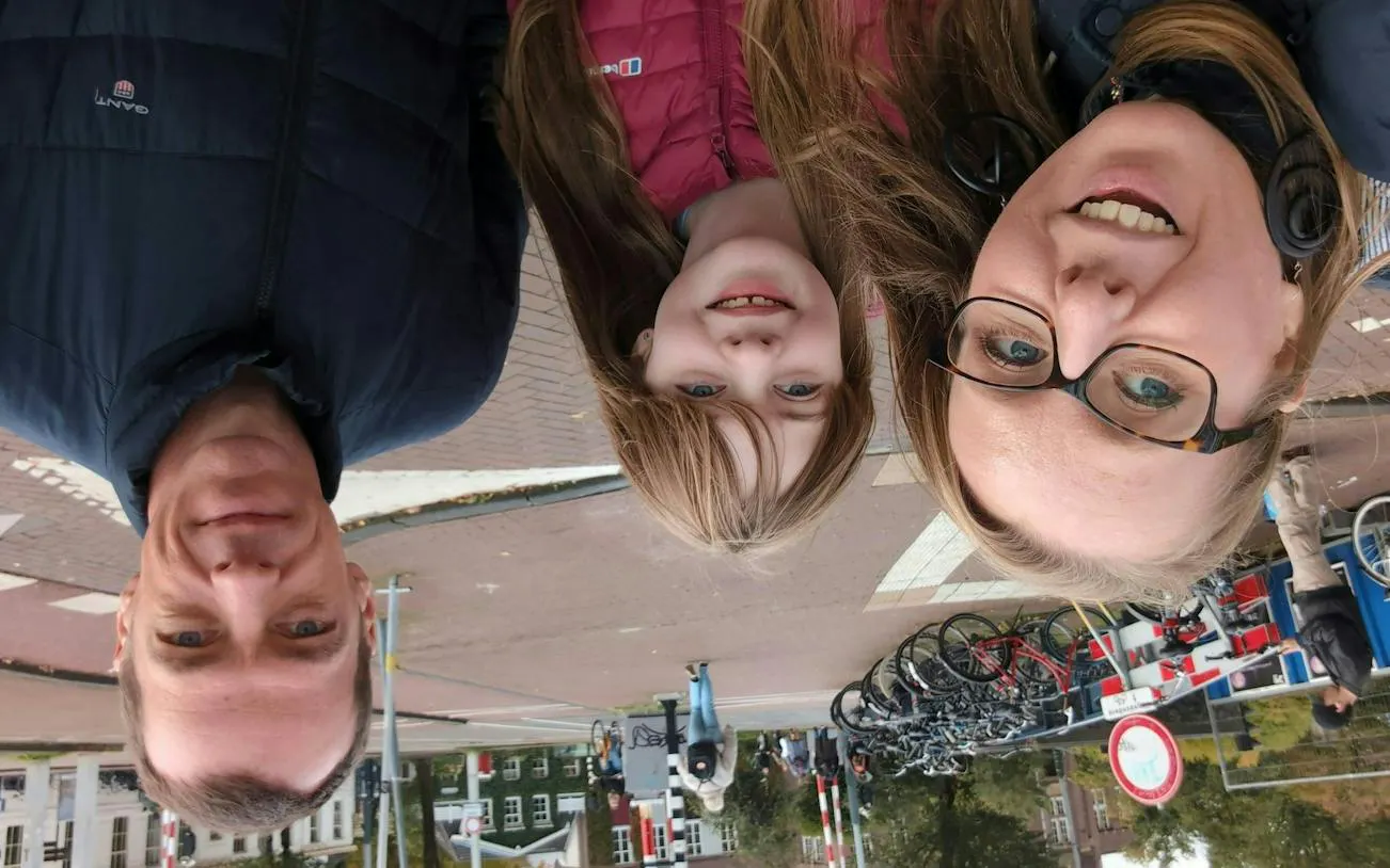 Family exploring Amsterdam street with bicycles, part of the Self-Guided City Exploration Game.