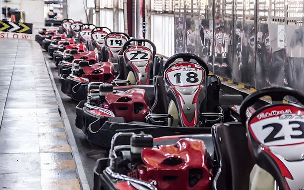 Indoor go-karts lined up at a track in Bangkok.