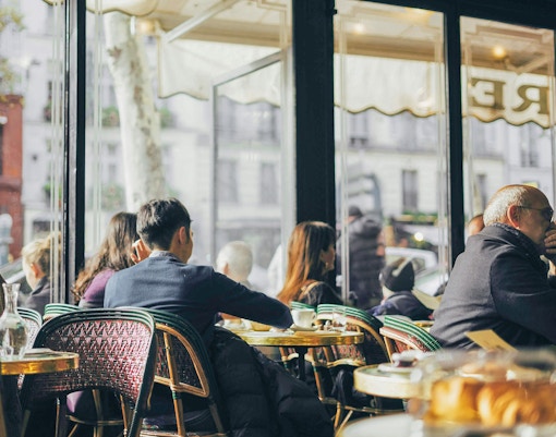 Patrons seated inside Café de Flore, Paris, enjoying coffee and conversation.