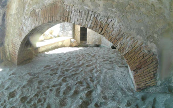 Ancient brick archway on sandy beach, Posillipo Coast, Naples.