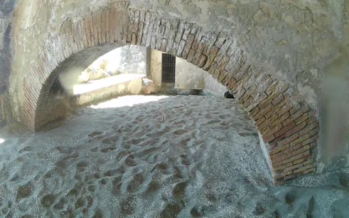 Ancient brick archway on sandy beach, Posillipo Coast, Naples.