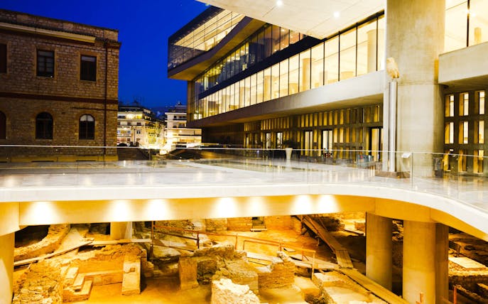 Acropolis Museum exterior with ancient ruins in Athens, Greece.