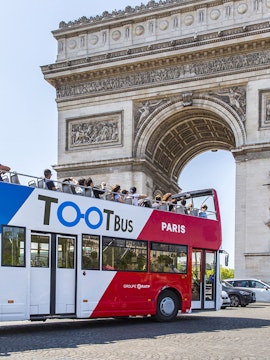 Open-top Tootbus passing by the Arc de Triomphe in Paris.