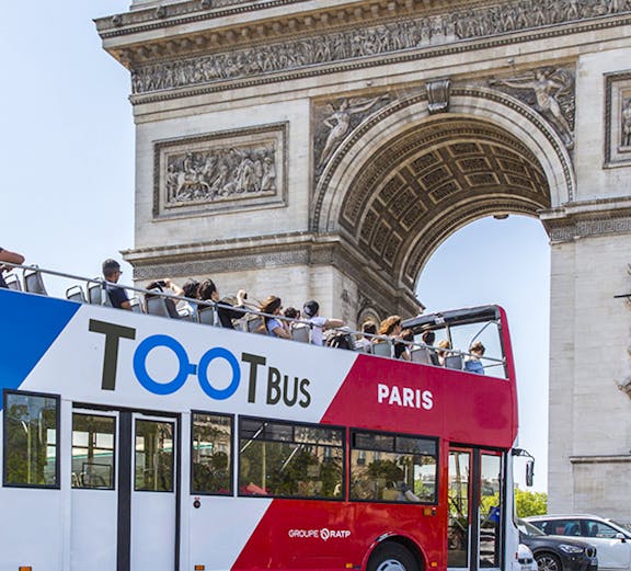 Open-top Tootbus passing by the Arc de Triomphe in Paris.
