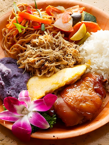 Imu-roasted dishes with rice, noodles, and purple sweet potato at Luau Kalamaku buffet.
