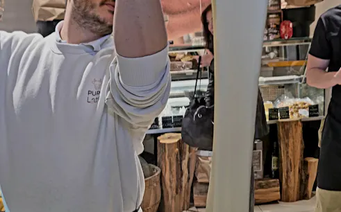 Man stretching fresh pasta dough in Padova market during food tour.