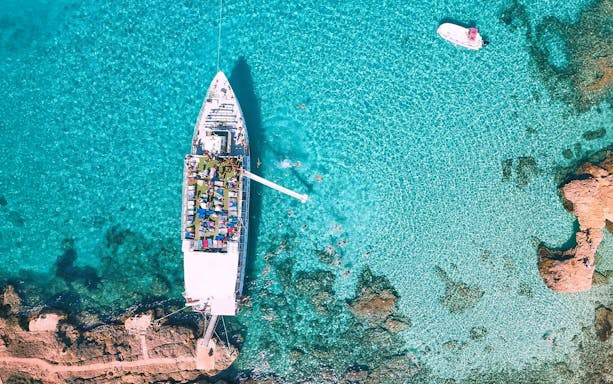Cruise ship sailing in Blue Lagoon, Malta, viewed from above.