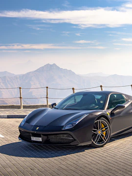 Supercar parked on a scenic mountain road in Dubai during a tour.