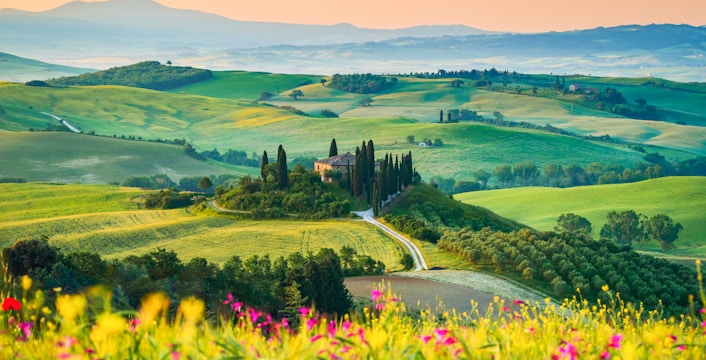 Tuscany landscape with rolling hills and cypress trees in San Quirico d'Orcia, Italy.