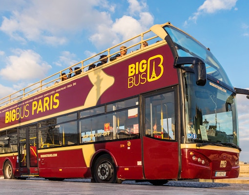 Tourists boarding the Big Bus in front of the Pantheon entrance in Paris, ready for a day trip around the city's major attractions