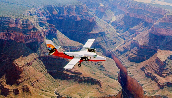 Aircraft flying over the Grand Canyon with a view of the canyon's vast landscape.